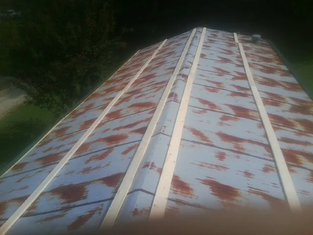 Rusted metal roof panels with new wood purlins before replacement — Storm Damage Roof Repair in Gladwyne by Roofing Brothers