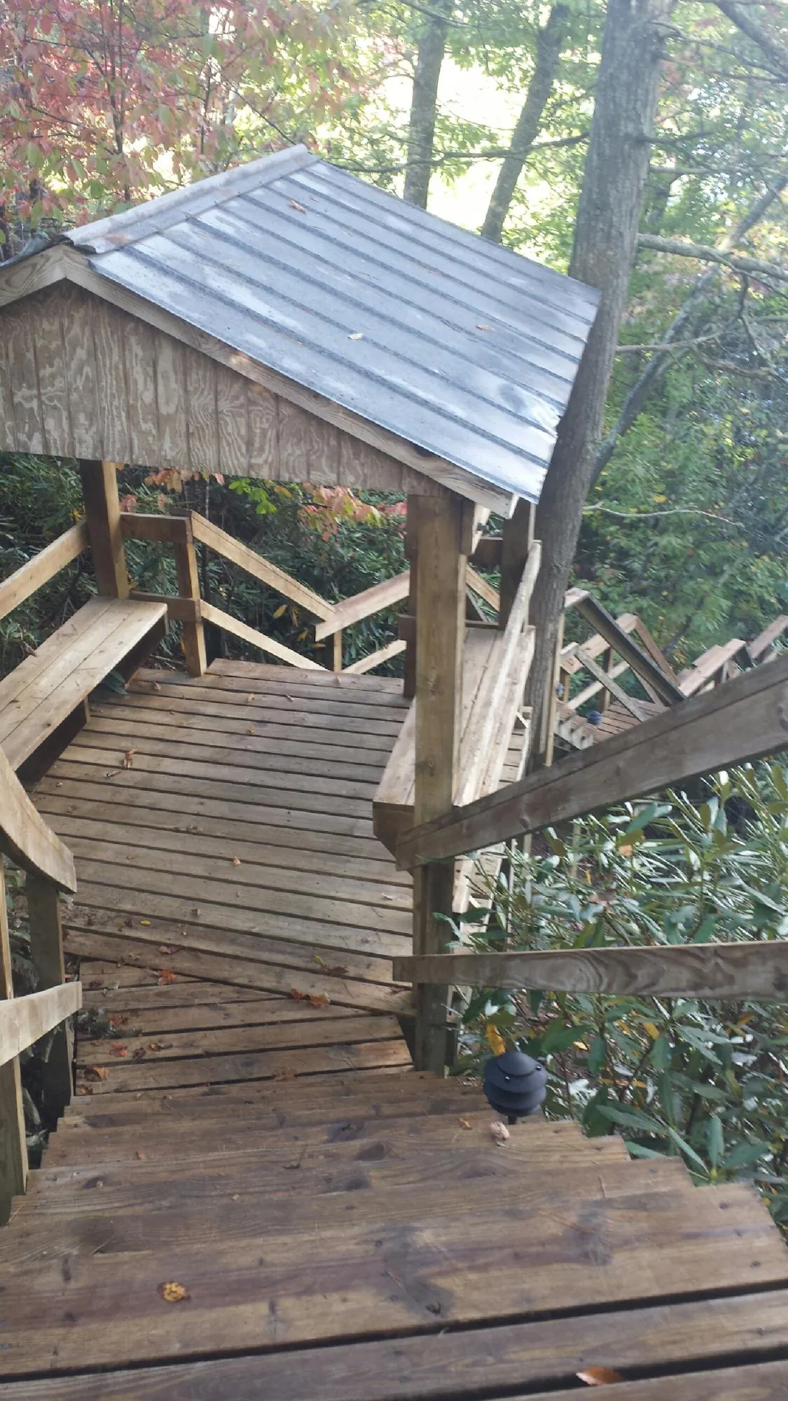 Metal roofed shelter over wooden steps on a wooded walkway — Skylight Repair & Installation work by our crew in Gladwyne