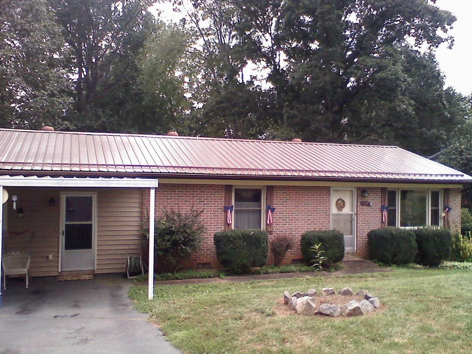 Bronze metal roof and carport on a brick ranch home — Roof Repair work by our crew in Gladwyne